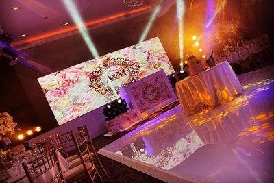 Elegant wedding reception setup with floral decor and initials A&M on display.