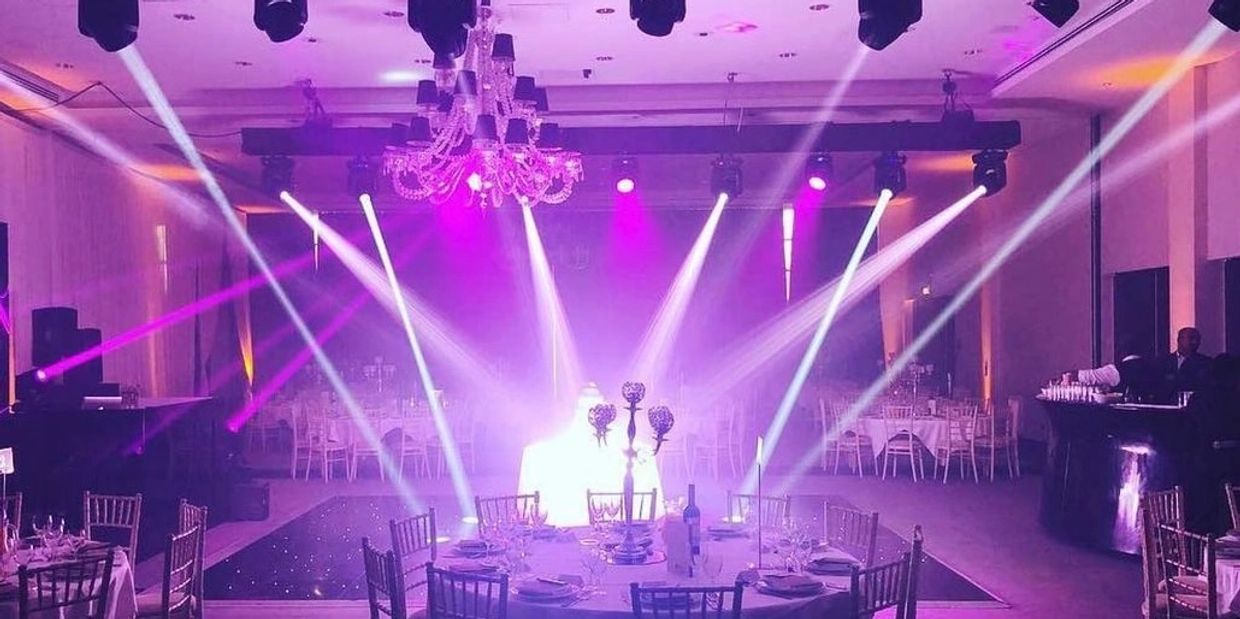 Elegant event hall with vibrant purple lighting and spotlights.