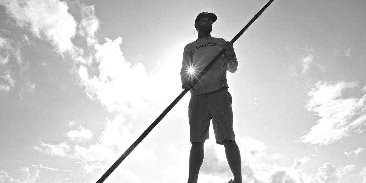 Capt. Marcus poling fly fishing clients searching for redfish 