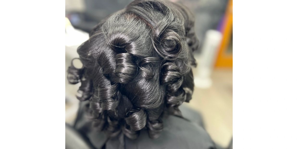Shiny black hair styled in defined, voluminous curls.