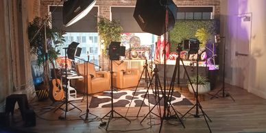A cozy studio setup for a video or photo shoot with lights and cameras.