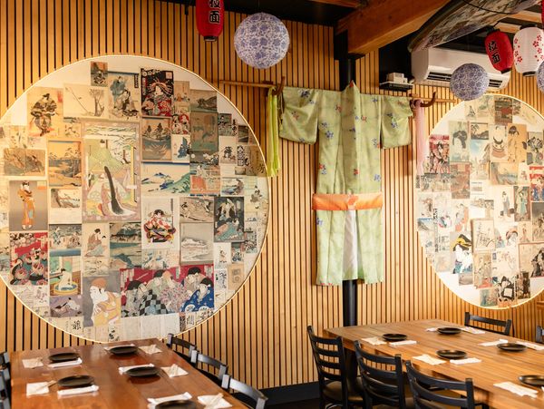 Interior view of Mura Izakaya in Kōloa with vintage Japanese prints and kimono wall decor