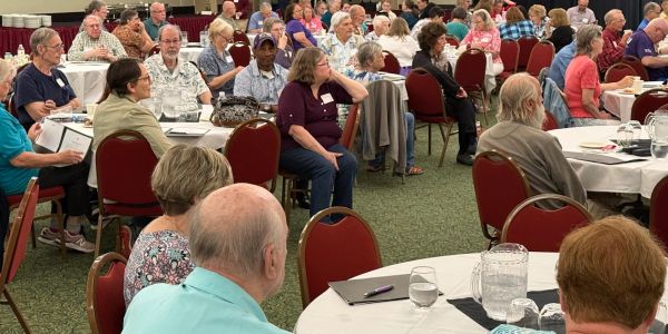 Large group of people seated at a conference or meeting.