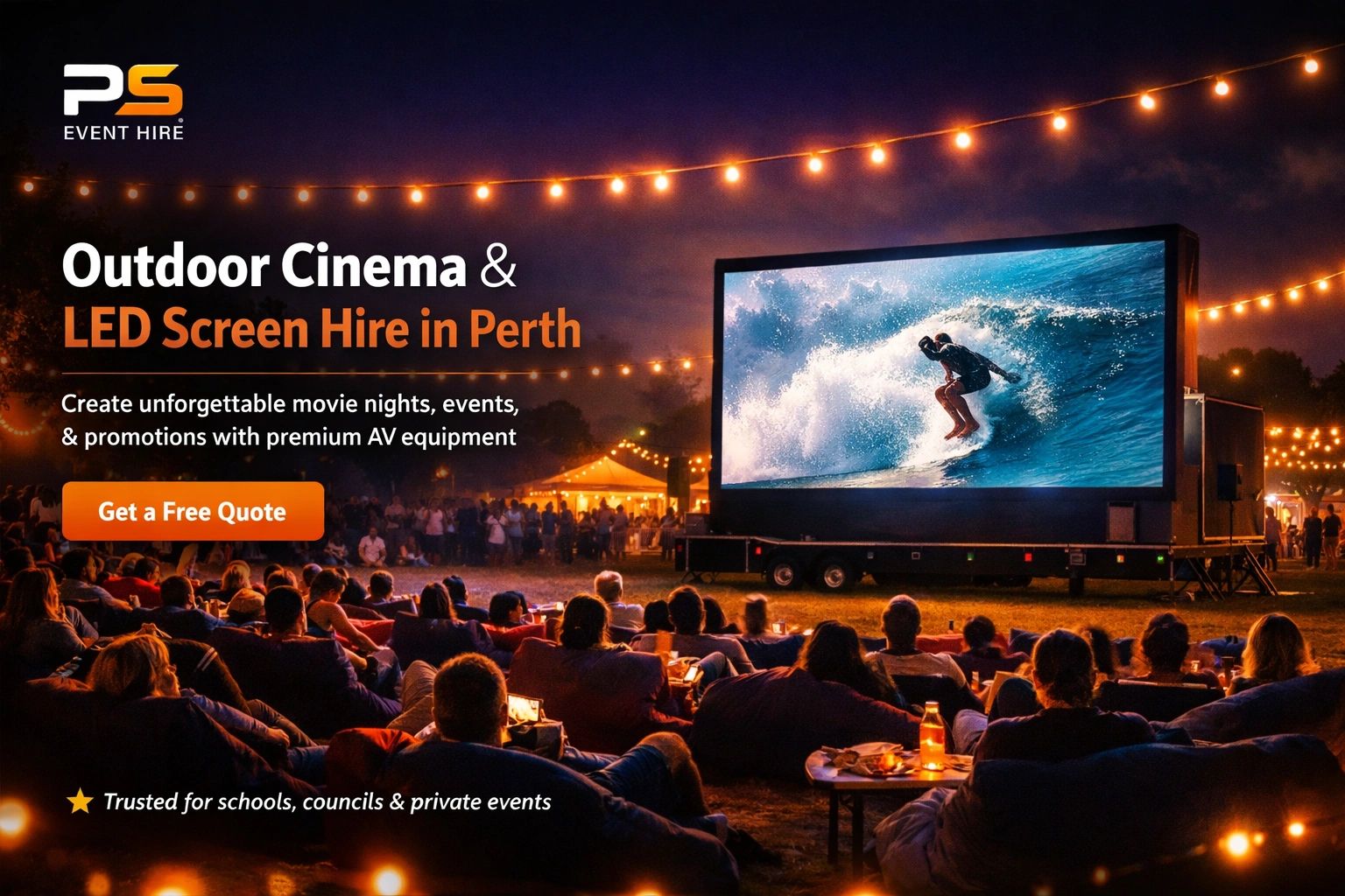 People enjoying an outdoor cinema event with a large LED screen and string lights at night.