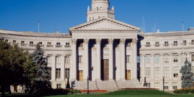 Historic government building with classical columns and a bright blue sky.