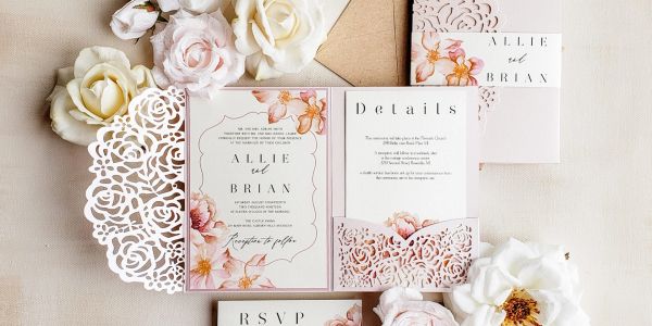 Elegant floral wedding invitation set with intricate laser-cut designs and soft pastel flowers.