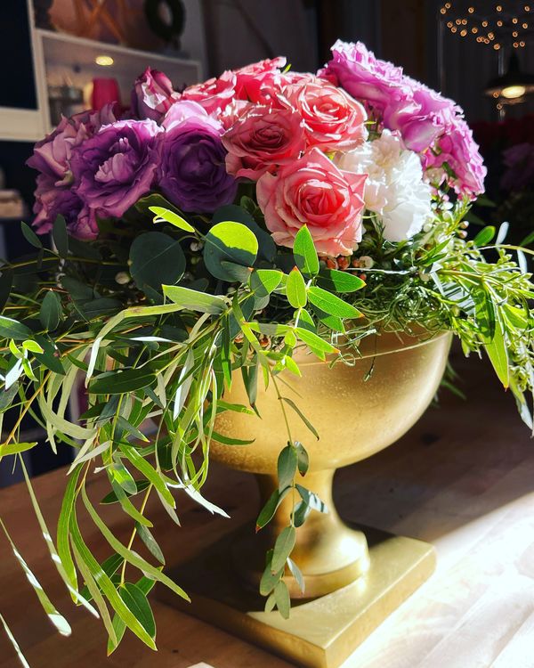 Roses in pink, lavender white, elegant birthday arrangement in a softly glowing gold footed bowl
