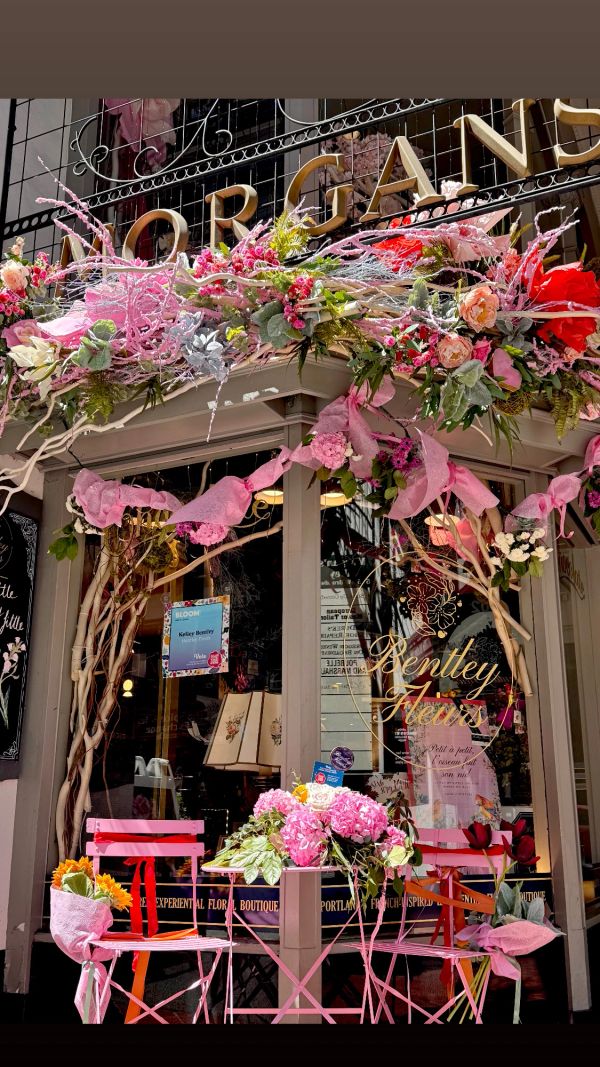 Charming flower shop with pink decor and outdoor seating.