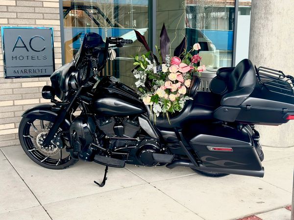 Harley Davidson black bike with memorial flowers