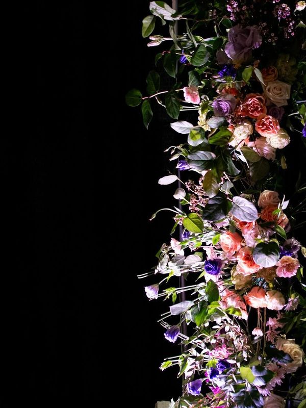 tall pole filled with flowers, fresh floral installation of peach roses, purple roses, purple flower