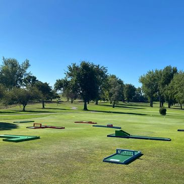 Portable mini golf course set up outside on an open green field