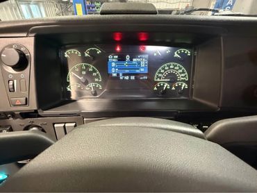 Dashboard display of a vehicle showing various gauges and digital information.
