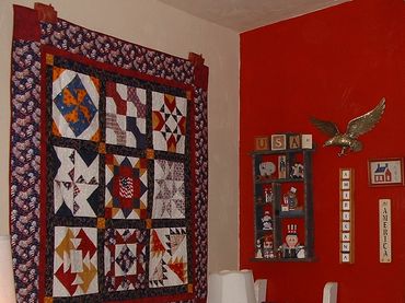 A cozy room corner decorated with colorful quilts and lamps.