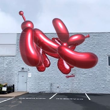 Shiny balloon dog doing downward dog yoga pose.