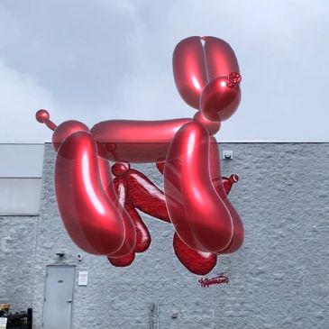 Shiny balloon dog looking at the camera.