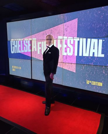 Man posing on red carpet at Chelsea Film Festival.
