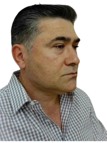 Profile of a middle-aged man with gray hair wearing a checkered shirt.