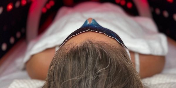 Person resting under a light therapy mask.
