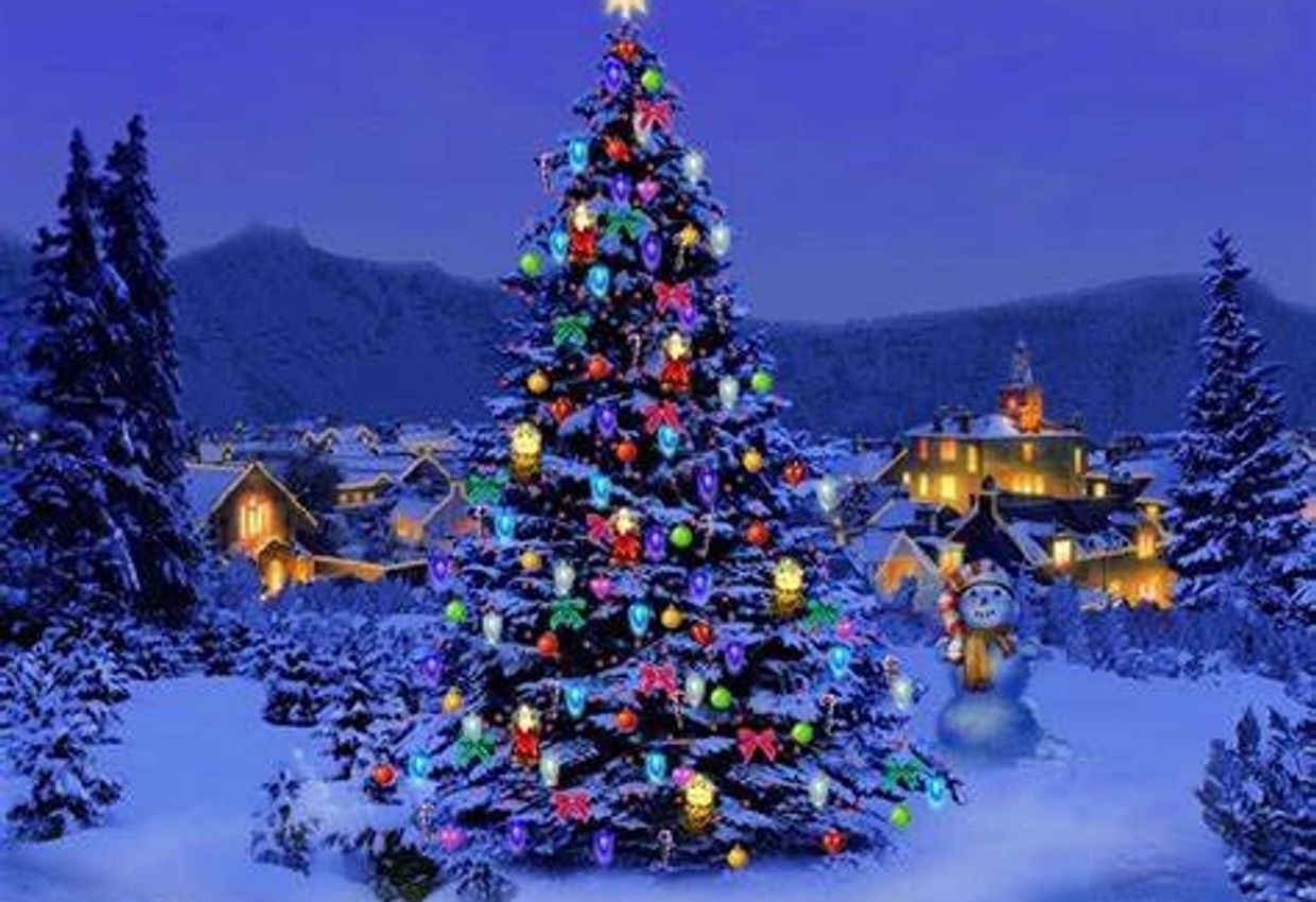 A brightly decorated Christmas tree in a snowy village at night.
