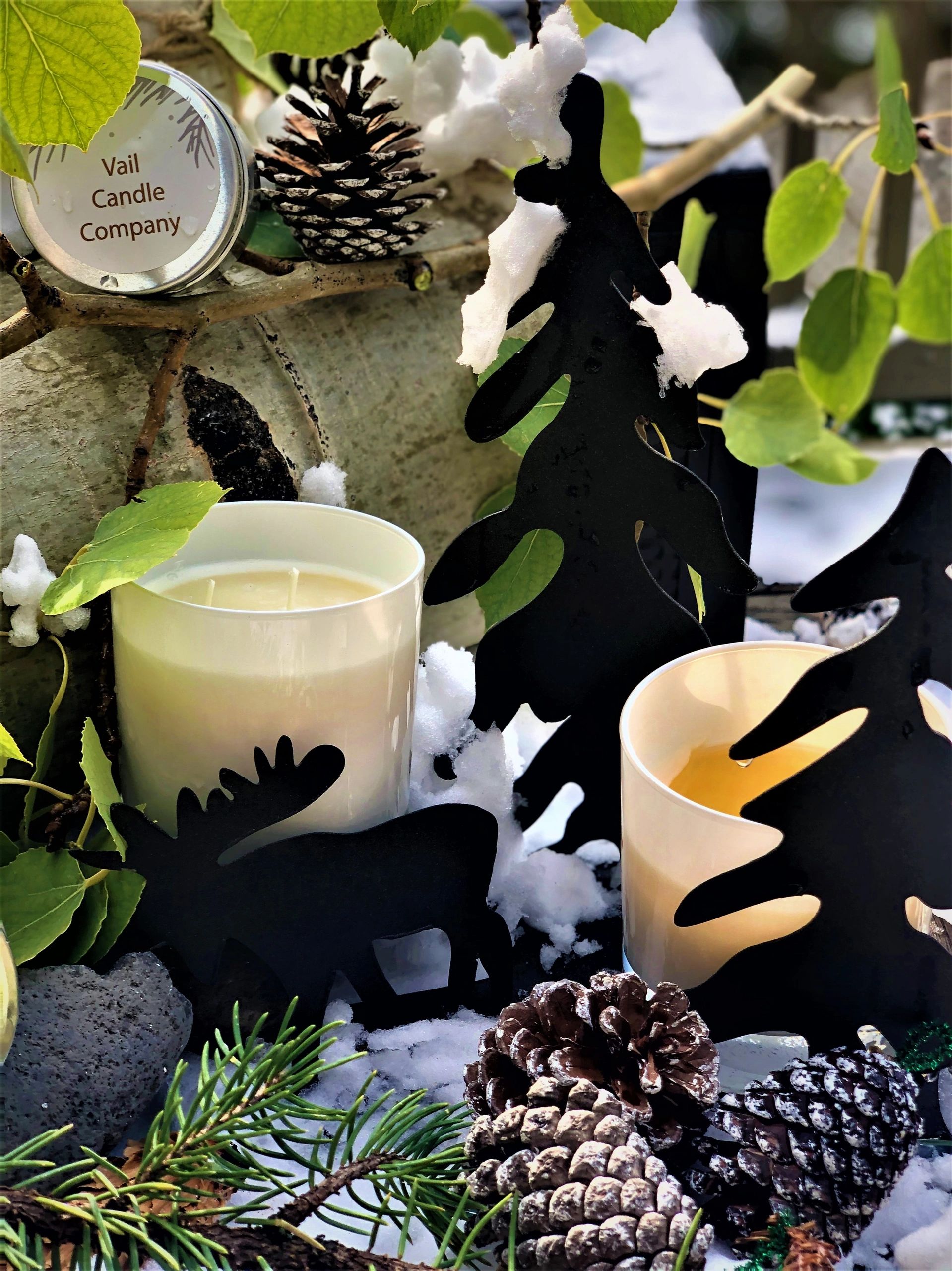 Luxury Candles in Vail Valley Colorado, surrounded by pine cones, aspen tree leaves and snow.