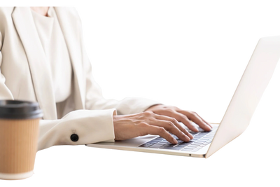 Person typing on a laptop with a coffee cup nearby.