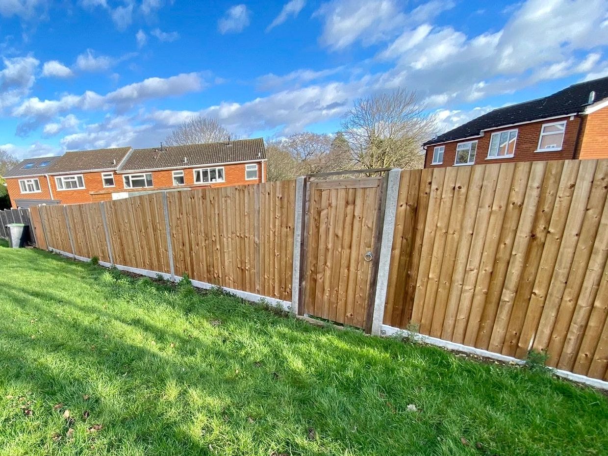 New wooden fence with a gate in a residential area.