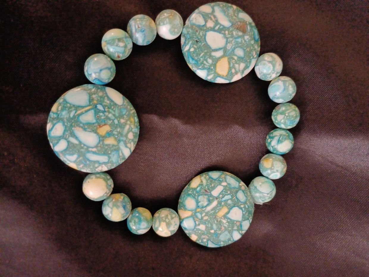 Turquoise beaded bracelet with circular stone patterns.