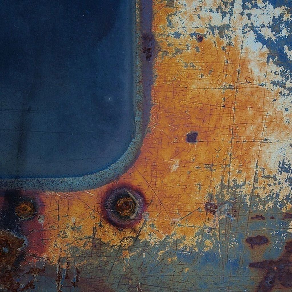 Photography close-up on an old 1963 VW Truck.  #5 in a series, Rusty orange, blue white, abstract