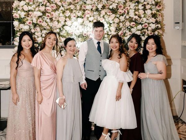 Elegant bridal party photo with pastel-colored bridesmaid dresses.
