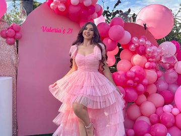 A girl wearing a pink dress is giving a pose in front of  the backdrop, Birthday Events