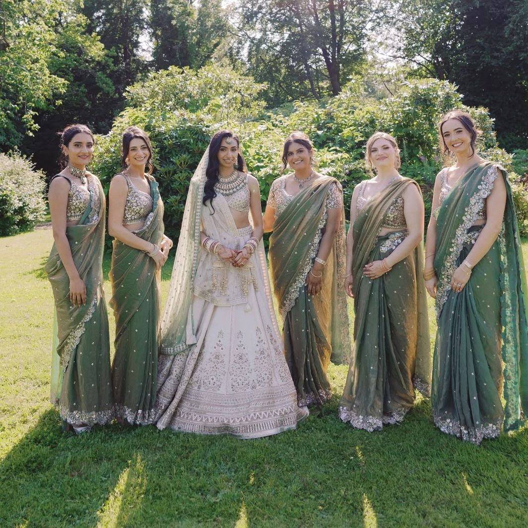 Bridal party in traditional attire outdoors.