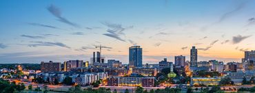 City skyline at sunset with buildings and lights.