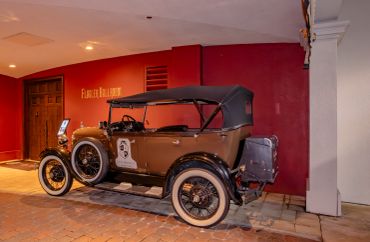 Classic vintage car parked indoors with red walls.