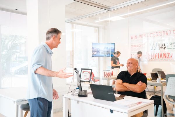 Two men engaging in a lively conversation in a modern office.