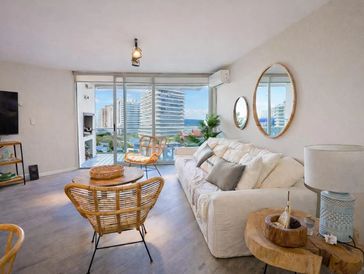 Bright living room with modern furniture and balcony view.