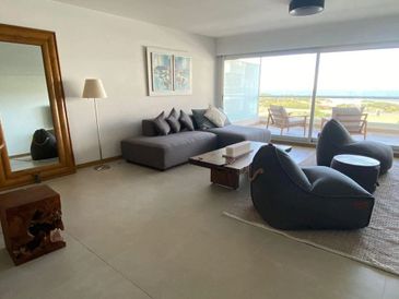 Modern living room with large window and stylish furniture.