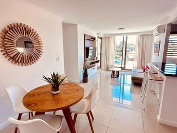 Bright, modern living and dining area with wooden accents and large windows.