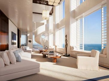 Bright, modern living room with large windows and ocean view.