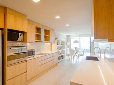 Modern kitchen with wooden cabinets and white countertops.