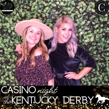 Two women smiling at a Kentucky Derby casino night event.