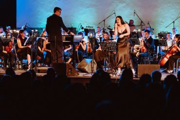 Orchestra performance with a female soloist and conductor.