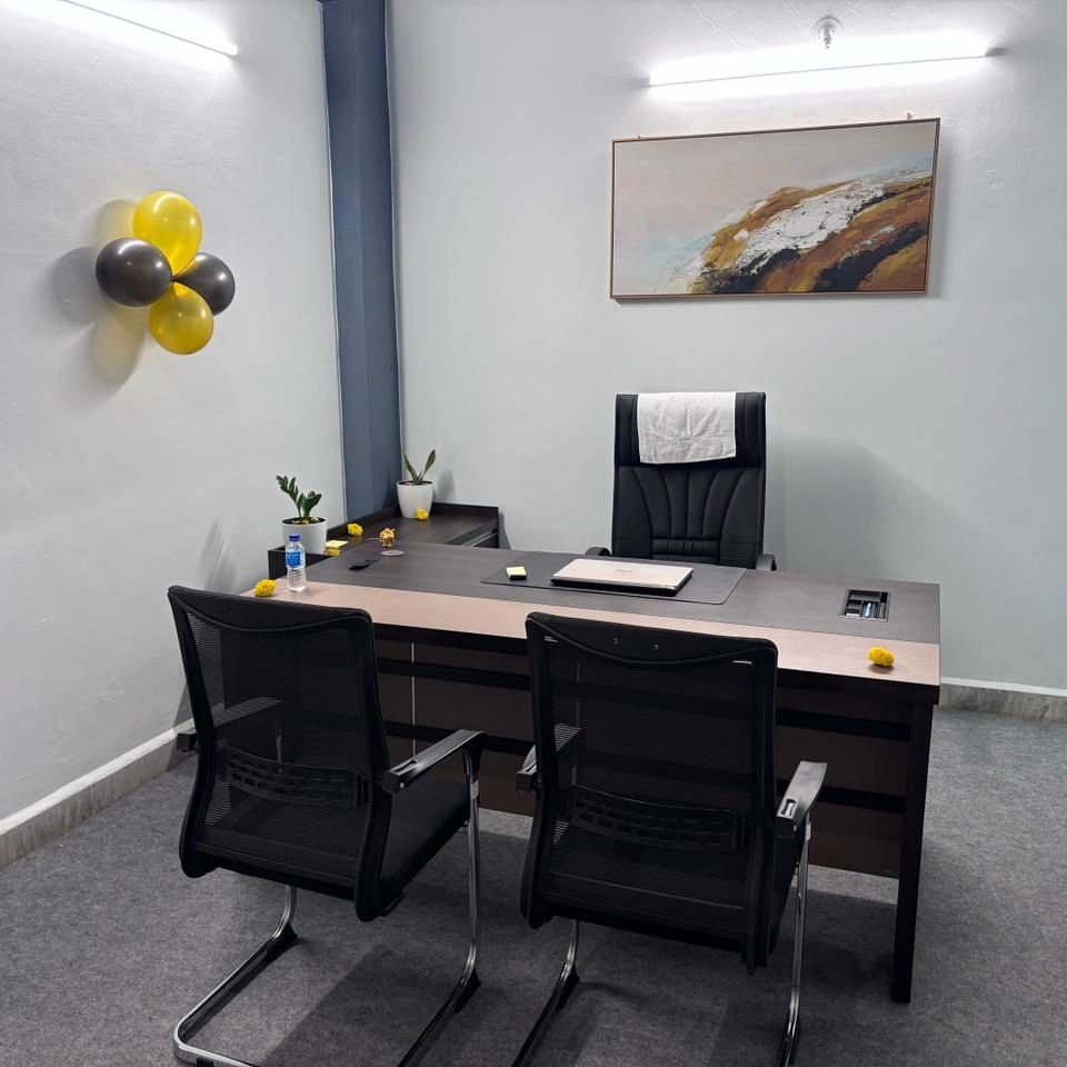 Modern office setup with a desk, chairs, and decorative balloons.