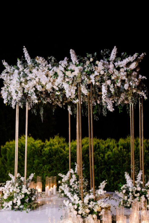 Outside floral arch, white stage with glass vase, wedding planner designer decor, vases with candles