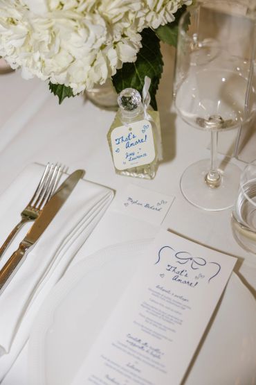 Elegant wedding table setting with personalized notes and white flowers.