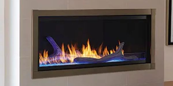 A fireplace with flames in it is mounted on the wall.