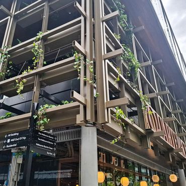 Quarterhouse building facade featuring custom aluminium planter boxes with lush greenery, integrated