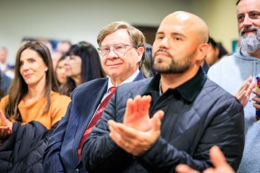 People attentively clapping at an event.