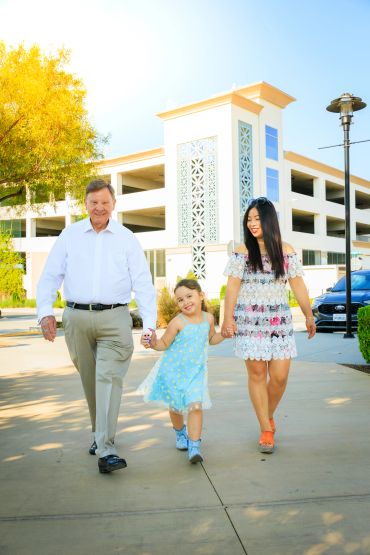Family walking together outdoors on a sunny day.