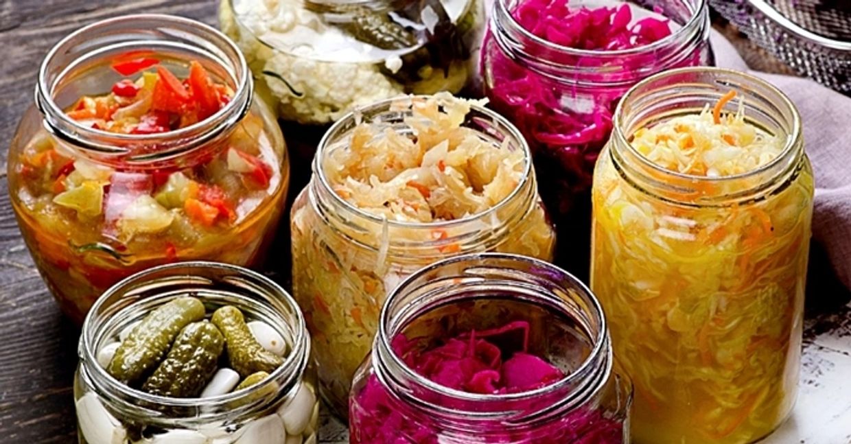 Image of a wide range of fermented food products, including beetroots, gherkins, sauerkraut et alia.