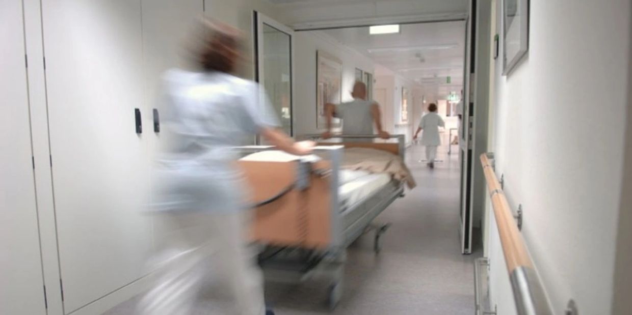 New hospital patient being transported down the corridors of a hospital to their destination ward.